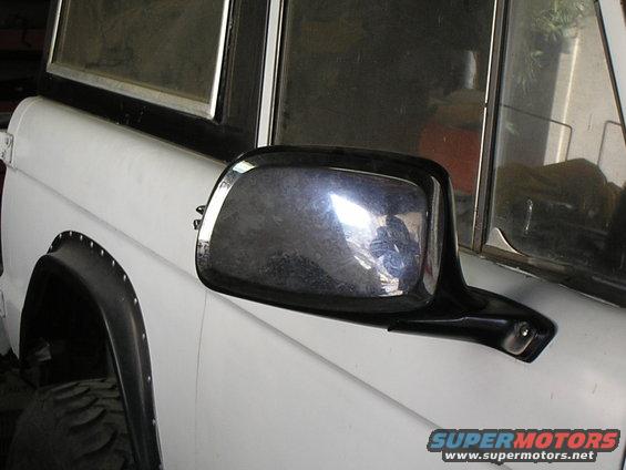 White 1966 Ford Bronco side view with chrome side mirror and black fender flare