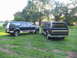 1995 Ford C-350 (Centurion Conversions) - Two Ford C-350 Centurion Conversions SUVs are parked on a lawn with trees in the background.