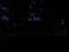 1995 Ford C-350 (Centurion Conversions) - A dark SUV is seen from the side at dusk, with another vehicle partially visible on the left.