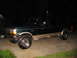 1995 Ford C-350 (Centurion Conversions) - A dark green Ford Bronco with tan lower trim is parked on a driveway at night.