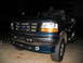 1995 Ford C-350 (Centurion Conversions) - Front view of a dark teal Ford truck with a chrome grille and amber turn signals.