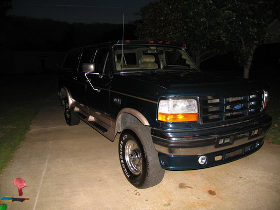 Dark green SUV with tan trim, 3/4 front view. Visible "Ford" badge on grille