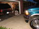 1995 Ford C-350 (Centurion Conversions) - Two Ford trucks are parked in a garage with a man sitting between them.