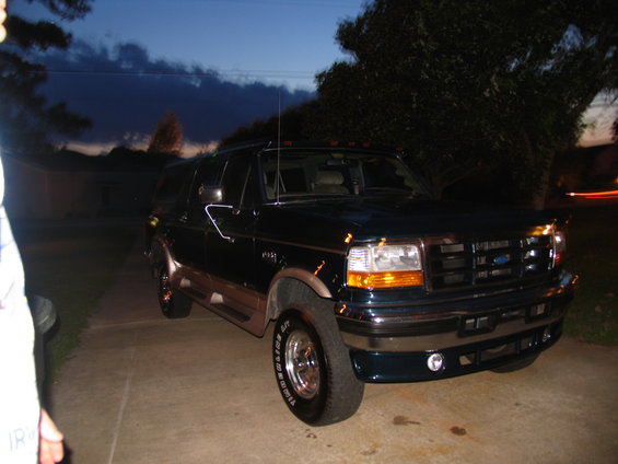 Dark green Ford Bronco parked on driveway at dusk