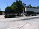1995 Ford C-350 (Centurion Conversions) - Two Ford Broncos are shown, with one loaded onto a trailer and being towed by the second vehicle.