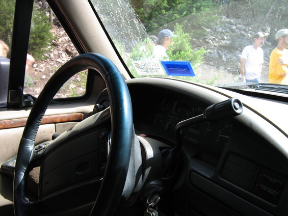 Interior of a 1992 Ford Bronco with a dark steering wheel and dashboard, showing a gear shifter and dashboard gauges