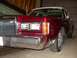 1989 Lincoln Town Car - The front end of a red 1989 Lincoln Town Car is shown, a prominent chrome grille and dual rectangular headlights.