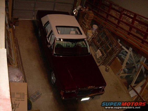 1989 Lincoln Town Car, maroon sedan with white vinyl top, parked in garage