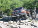 1996 Ford Bronco - This Ford F-Series truck is tackling a challenging off-road trail with other vehicles following.
