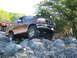 1996 Ford Bronco - A maroon Ford Bronco navigates a rocky trail, with another off-road vehicle visible behind it.