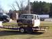 1992 Lincoln Custom - Cab of a pickup truck being transported on a trailer, with another truck visible.
