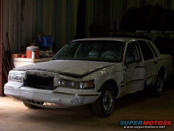 White 1992 Lincoln Custom sedan with front end damage and driver door ajar
