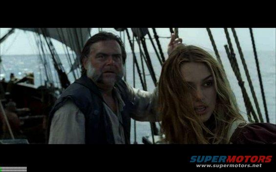 Man and woman on a ship deck with sails and rigging in the background