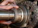 1991 Ford Bronco - Close-up of a hand adjusting engine timing components, including a chain and gears.
