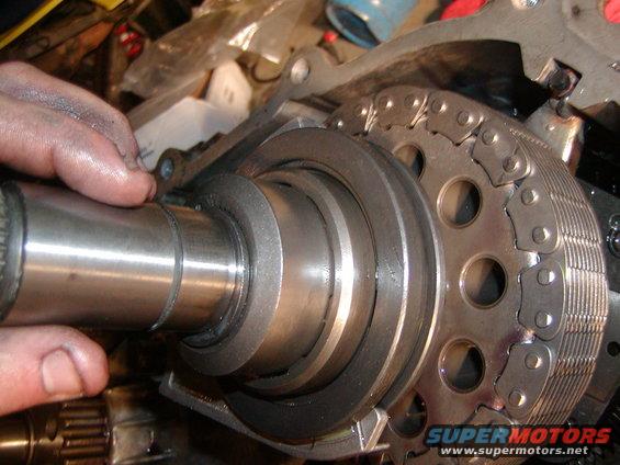 Engine timing chain and camshaft assembly with a hand holding a metal shaft