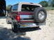 1996 Ford Bronco - Rear view of a maroon Ford Bronco parked outdoors on a gravel surface.