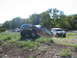 1996 Ford Bronco - A maroon 1996 Ford Bronco navigates an off-road incline, with a white SUV visible in the distance.