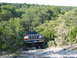 1996 Ford Bronco - 1996 Ford Bronco navigating a rough, wooded trail.