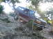 1996 Ford Bronco - This Ford Bronco is navigating a steep, rocky incline surrounded by trees and brush.