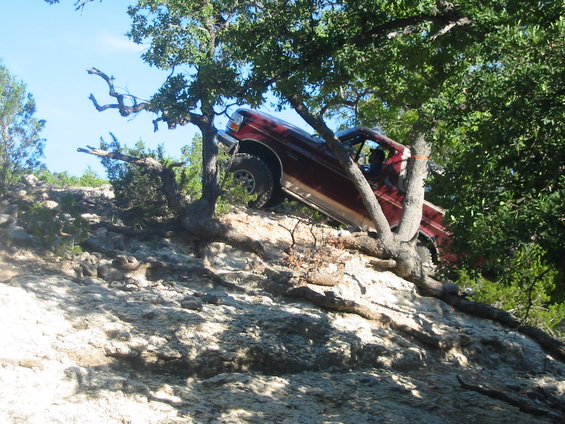 Red 1996 Ford Bronco climbing a rocky incline