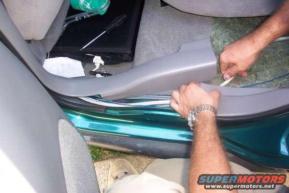 back seat pulled out and up...wiring ran under sill and seat