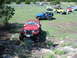 1996 Ford Bronco - A group of Jeeps are gathered in a grassy, hilly area with scattered trees.