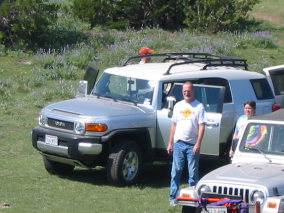 Silver Toyota FJ Cruiser with doors open, people standing nearby