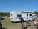 1996 Ford Bronco - An RV is parked on a grassy area under a clear blue sky, with other vehicles visible in the background.