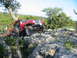 1996 Ford Bronco - A red Jeep Wrangler navigates a rocky off-road trail with a second vehicle in the background.