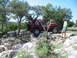 1996 Ford Bronco - A red Jeep Wrangler is shown off-roading on a rocky path, with a person standing to the side.