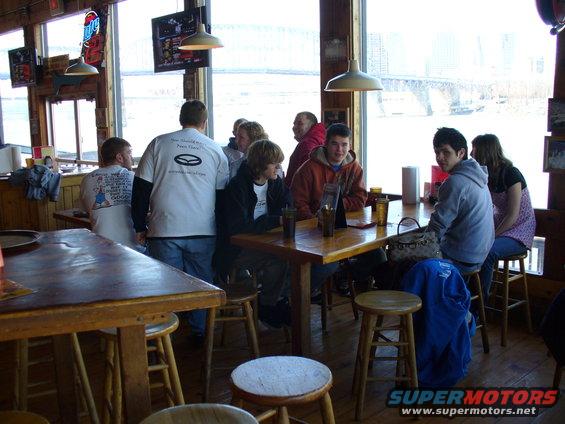 People gathered inside a restaurant with large windows overlooking a snowy landscape