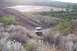 1995 Ford Bronco - SUV driving through a , natural landscape with a body of water in the distance.
