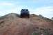 1995 Ford Bronco - Black Ford Bronco navigates a steep dirt incline under a cloudy sky.