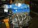 1996 Ford Probe - Engine with blue intake manifold and chrome exhaust headers, mounted on an orange engine stand in a workshop.