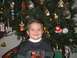 2002 Ford Taurus - A young child poses for a photo in front of a Christmas tree adorned with various ornaments and lights.