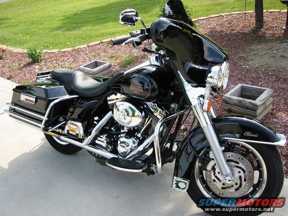 Black 2004 Harley-Davidson Electra Glide Clsc motorcycle parked on a concrete driveway, with a large windshield and saddlebags