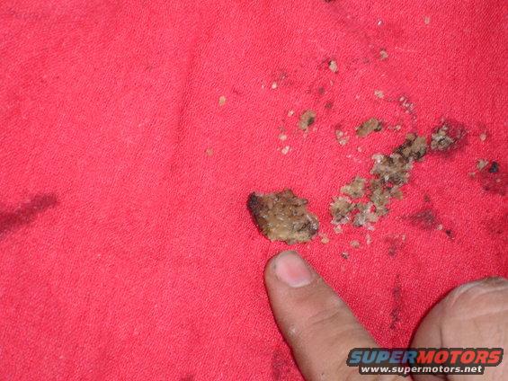 Close-up of gritty, greasy substance on red fabric