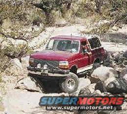 Red 1993 Ford Bronco navigating rocky terrain