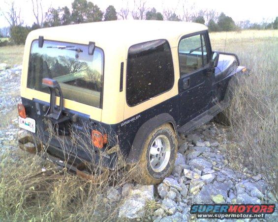 Jeep Wrangler off-road, stuck on rocks and grass. Two-tone black and tan