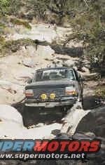 Dark-colored Ford Bronco navigating a rocky off-road trail