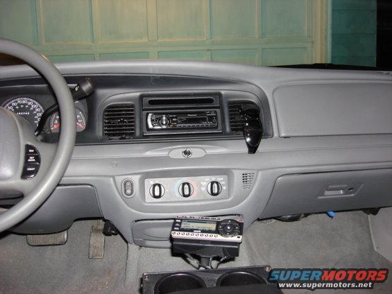 Car interior showing dashboard with two radios and steering wheel