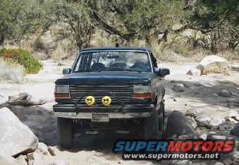 Black Ford Bronco with yellow fog lights, front view, off-road