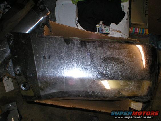 Chrome bumper part, possibly for a truck, resting on cardboard