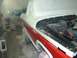 1978 Ford Bronco - A two-tone red and white pickup truck is being prepped for paint in a booth, with its hood open to reveal the engine bay.