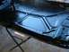 1978 Ford Bronco - The underside of a car hood, recently painted black, is supported by a metal stand.