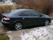 1994 Ford Probe - A black sedan is parked on a driveway with patches of snow and ice.