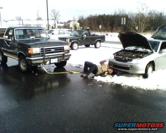 Stuck honda hybrid at work. Guy backed up into a parking space that hadnt been plowed (at the time he pulled in the whole parking lot wasnt plowed) and got stuck/high centered.  I was digging under it to find an anchor point on the frame....this was before he found his tow bolt that attaches into the front bumper...