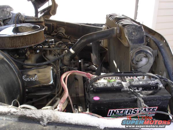 Engine bay with Interstate battery, chrome air cleaner, and radiator. Snow is visible on the hood