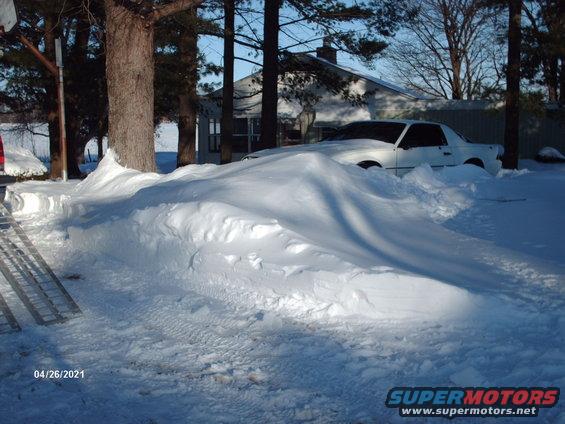 white coupe stuck in a huge snowdrift