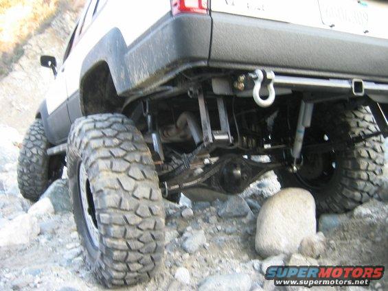 1985 Toyota 4Runner rear axle, suspension, and large off-road tires on rocky terrain